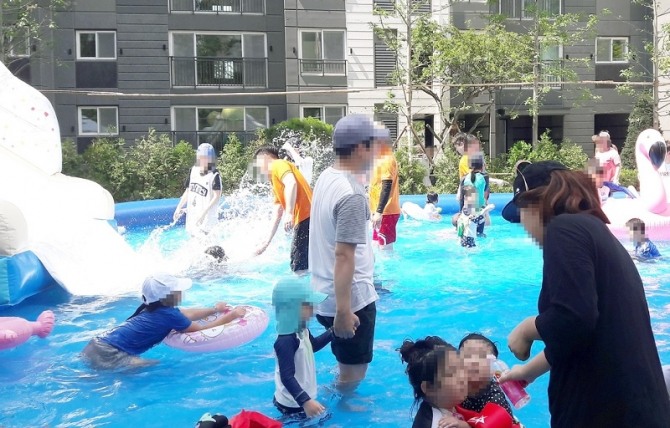 SK건설이 지난 10일 경기도 화성 'SK뷰파크 3차' 단지에서 입주민을 위한 여름나기 고객감사행사를 열었다. 입주민들이 행사장에 설치된 야외물놀이시설에서 자녀들과 즐겁게 물놀이를 하고 있다. 사진=SK건설