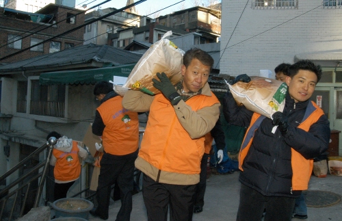 ▲국민연금관리공단직원들이남대문쪽방에사랑의쌀을배달하고있다.