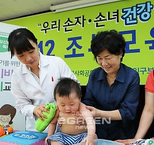 ▲할머니가아기의건강관리법을배우고있다.