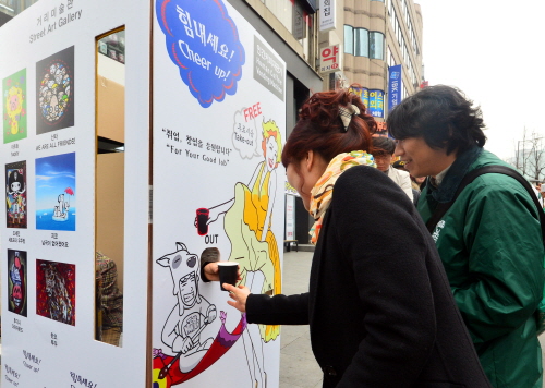 ▲서울동교동홍대입구역에서한성수펠릭스파버대표가구직을돕는만화캐릭터'잡헌터'가면을쓰고인간자판기안에서구직활동에지친청년과업무에시달리는직장인을응원하기위해직접커피를타시민에게나누어주고있다.