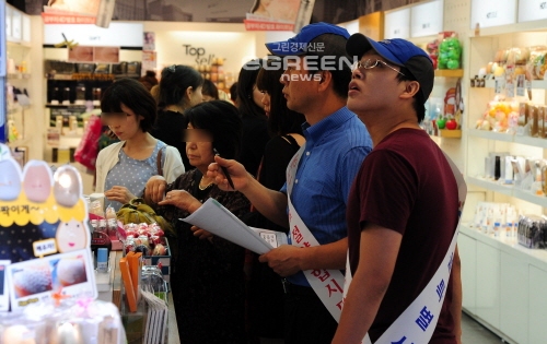 ▲서울시관계자들이에너지관리공단과함께중구명동거리에서에너지낭비를하는상점들의개문냉방영업행위에대한단속활동을펼치고있다.