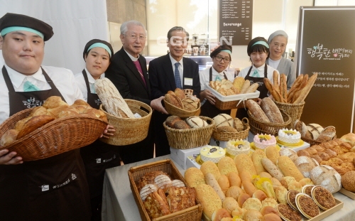 ▲서울종로구푸르메센터에서열린'장애인이직접운영하는행복한베이커리&카페1호점오픈식'에서조상호SPC그룹총괄사장(가운데)및참석자들이빵을들고포즈를취하고있다.