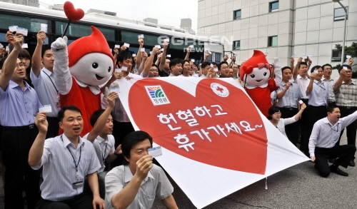 ▲서울동대문구신설동대상빌딩주차장에서혈액수급이어려운여름휴가철을맞아대상그룹임직원들이헌혈증서를들고파이팅을외치고있다.