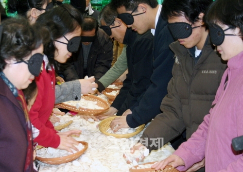 ▲서울양재동농협하나로마트에서열린'한석봉어머니의마음으로행운의떡국떡담기'행사에참가한시민들이바구니에떡을담고있다.