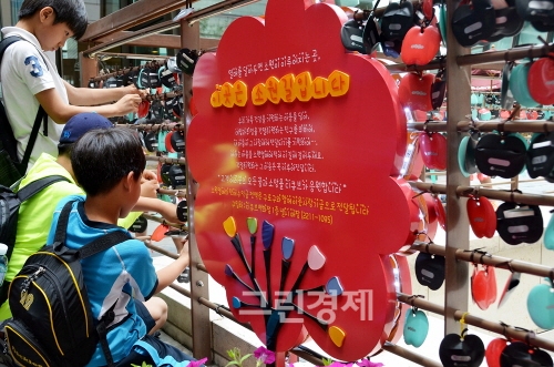 ▲대성산업이운영하는디큐브백화점내인기명소인‘소원길’에서인근초등학교학생들이지난7월여름방학을맞아‘소원열매달기’를진행하고있다.