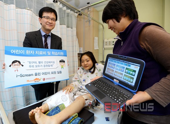 아이스크림홈런최형순전무(왼쪽)가고려대학교구로병원에입원해있는환아를찾아아이스크림홈런초등학생회원들의응원메시지를전달하는등환아와가족들을격려하고있다.