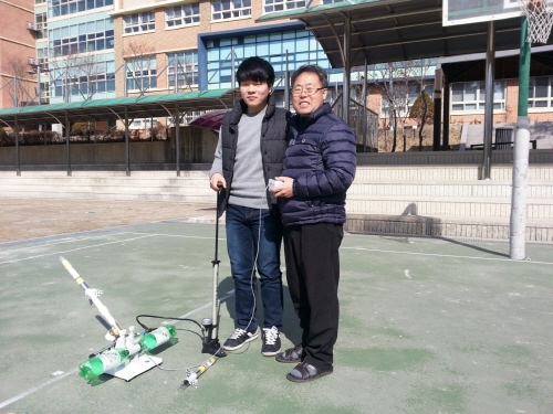 운중고 정만교 교장(오른쪽)과 이재용 군이 에어로켓 발사대 앞에서 포즈를 취하고 있다. 