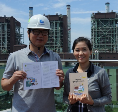 한국중부발전 직원들이 발간된 책자를 소개하고 있다.
