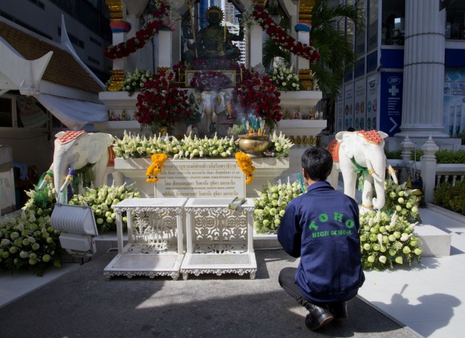 17일(현지시간) 태국 방콕 관광 명소인 에라와 사원에서 폭탄 테러가 발생, 외국인 7명을 포함한 21명이 사망하고 120여 명이 부상했다. 사진은 한 남성이 폭발 다음날인 18일 아침 에라완 사원 인근에서 기도하는 모습. /사진 = 뉴시스