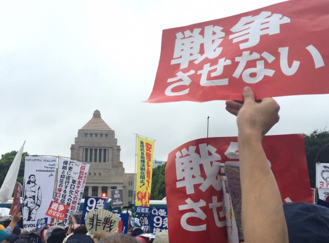 30일(현지시간) 일본 도쿄에서 열린 안보법에 반대하는 집회에서 한 시위대원이 '전쟁을 하면 안 된다'고 쓰인 플래카드를 들고 있다. 이날 의회 주변에서 열린 집회에 약 12만 명의 사람들이 참가해 아베 신조 총리에게 법안 철회를 요구했다. /사진 = 뉴시스