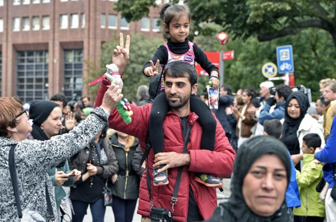 유럽의 양대 축인 독일과 프랑스가 난민 수용 인원을 대폭 늘리기로 했다. 사진은 6일(현지시간) 특별열차편으로 독일 도르트문트에 도착한 난민 부녀에 현지 주민이 인형을 선물하고 있는 모습. /사진 =뉴시스