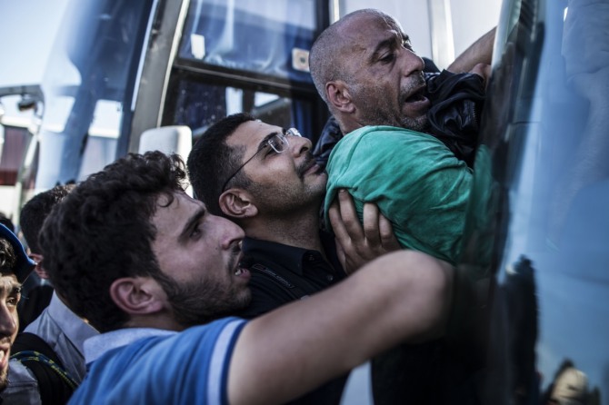 독일 정부가 18일(현지시간) 유럽연합(EU) 회원국 간 난민 수용 부담을 나누는 '난민 쿼터제'를 표결을 거쳐서라도 관철시키겠다는 의지를 피력했다. 사진은 크로아티아 국경도시 토바르니크에서 전날 난민들이 버스에 올라타려고 안간힘쓰고 있는 모습. / 사진 = 뉴시스 