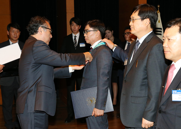 한정화 중소기업청장(왼쪽)이 이상길 ㈜성우 대표이사에게 은탑산업훈장을 수여하고 있다.