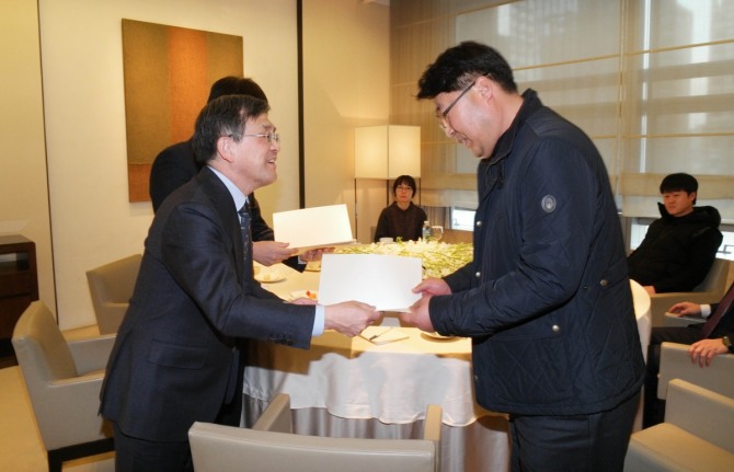 삼성전자 권오현 대표이사(부회장·왼쪽)가 14일 삼성전자 서초사옥에서 가족대책위원회 송창호 대표에게 사과문을 전달하고 있다.