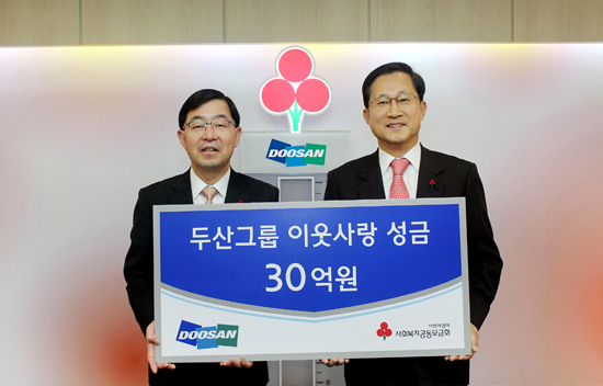 박완석 두산 부사장(왼쪽)이 김주현 사회복지공동모금회 사무총장에게 희망 나눔 성금을 전달하고 있다.