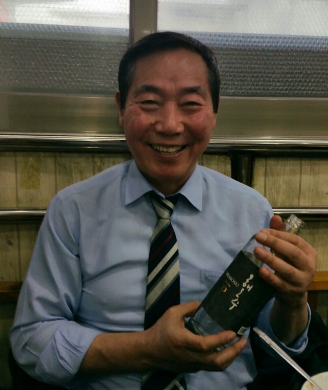 전통주 공동브랜드 '해모수'를 들고 활짝 웃고 있는 김홍우 한국전통주진흥협회 회장.