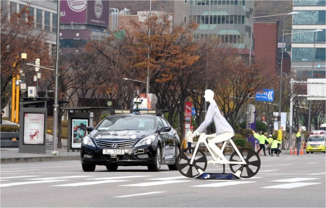 지난해 현대차가 서울 도심에서 진행한 자율주행차 시범 운행 모습이다. 횡단보도를 지나가는 자전거를 보고 자율주행차가 저절로 멈추고 있다.