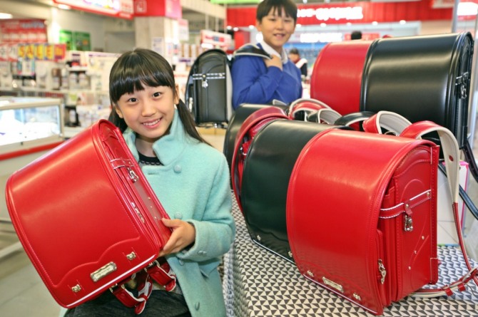 일본에서 초등학생들이 짊어지고 다니는 책가방 '란도셀' 조기 판매경쟁이 뜨겁다. 사진은 롯데빅마켓 영등포점에서 한 초등학생이 '란도셀' 가방을 선보이고 있는 모습. / 사진 = 뉴시스