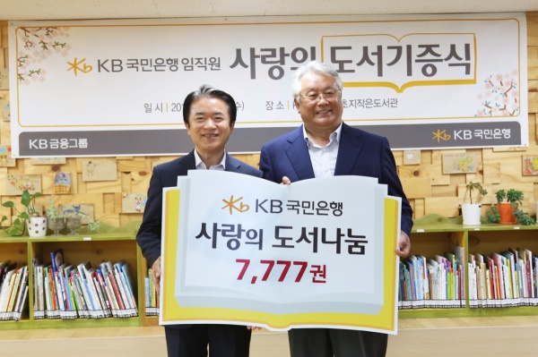 KB국민은행은 8일, 안산「초지 작은도서관」에서「사랑의 책 나눔–두번째이야기」캠페인을 통해<br />
임직원들이 기증한 도서와 신간 아동도서 등 총 7777권의 도서를 작은도서관에 전달했다. 왼쪽) KB국민은행 정용택 경기중앙지역영업그룹 대표와 (사)작은도서관만드는사람들 김수연 대표(오른쪽)가 전달식에서 기념촬영을 하고 있다. <br />
