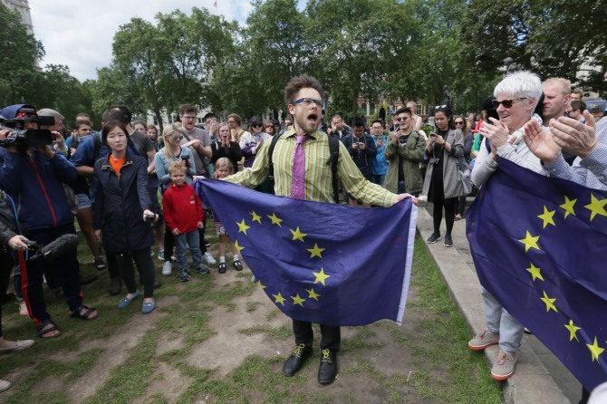 영국의 유럽연합(EU) 탈퇴에 반대하는 시위대가 25일 던던의 유럽광장에서 EU 깃발을 들고 시위를 벌이고 있다. 국민투표 전체 결과와 단리 영국의 EU 잔류가 우세했던 런던에서 런던이 영국으로부터 독립된 주로 승격돼 스코틀랜드와 함께 EU에 재가입해야 한다는 인터넷 서명 운동이 시작됐으며 순식간에 16만 명이 동참하는 등 호응을 얻고 있다. / 사진 = 뉴시스