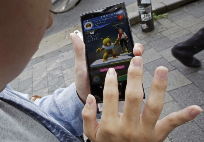 일본 닌텐도와 나이앤틱이 개발한 스마트폰용 증강현실(AR) 게임 '포켓몬 고(GO)'가 건강에 도움을 주고 있다는 주장이 속속 나오고 있다. 사진은 일본 도쿄 거리에서 한 남성이 포켓몬 고 게임을 하고 있는 모습. / 뉴시스 
