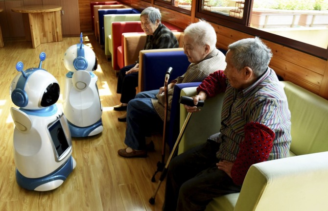 중국의 고령화로 부유층 노인이 빠르게 늘면서 보험사들이 이들을 겨냥한 실버산업에 앞다퉈 진출하고 있다. 사진은 중국 저장성 항저우의 한 요양원에서 노인들이 로봇 도우미들을 바라보고 있는 모습. / 뉴시스