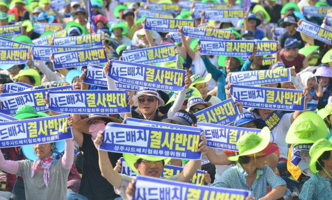 성주사드투쟁위원회는 21일 국방부에 제3후보지를 검토해 달라고 요청키로 했다. 사진은 15일 오후 경북 성주군 성밖숲에서 열린 ‘사드철회 평화촉구 결의대회’에서 성주군민들이 사드철회를 촉구하는 구호를 외치고 있는 모습. / 뉴시스