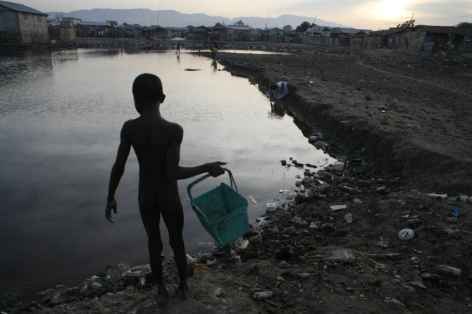 전 세계 인구 가운데 약 3억2300만명이 오염된 식수를 마시고 있으며 해마다 340만명이 이로 인해 사망한다고 유엔환경계획(UNEP)이 30일(현지시간) 보고서를 통해 발표했다. 사진은 생활하수로 심하게 오염된 아이티의 강 지류에서 한 소년이 저녁거리로 쓸 새우를 잡아 집으로 가고 있는 모습. / 뉴시스(Roger LeMoyne/유니세프한국위원회 제공)