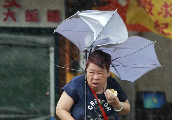제17호 태풍 메기가 27일 대만에 상륙하면서 한 여성이 타이베이에서 강풍에 우산을 쓰고 힘들게 뭔가를 먹고 있다. 태풍이 대만에 상륙하면서 휴교령 휴장, 항공편 결항 등 비상이 걸렸다 /뉴시스