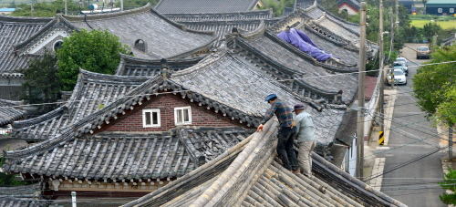 지난달 19일 발생한 지진으로 경북 경주시 황남동 사정경로당 기와지붕이 파손돼 인부들이 지붕 보수 작업을 하고 있다.사진/뉴시스