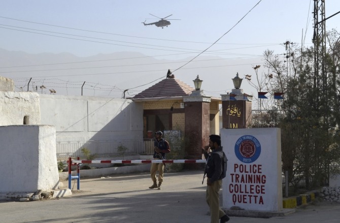 파키스탄 퀘타 경찰학교 입구에서 25일 경찰이 지키고 있다. 하루전 이 학교에서는 테러범들이 난입, 학생 일부를 인질로 붙잡고 군경과 총격전을 벌였다. 이번 사건으로 61명의 사망자가 발생했다. /사진=뉴시스