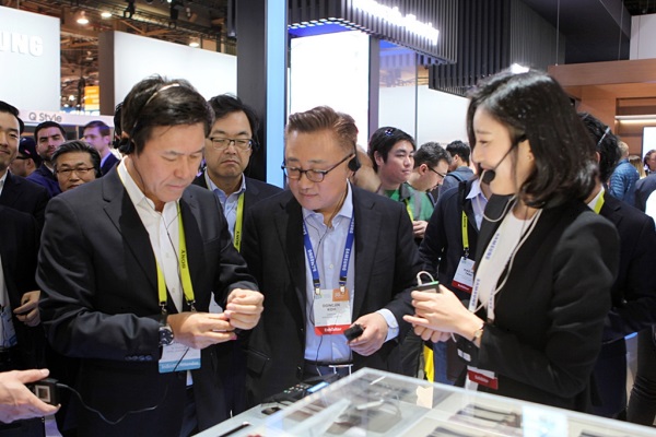 CES2017 삼성전자 부스에서 SK텔레콤 박정호 사장(왼쪽)과 삼성전자 고동진 무선사업부 사장(가운데)이 기어S3를 직접 착용해 보고 있다. 사진=SK텔레콤