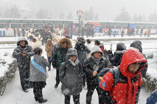 20일 강원 정선역에서 정선선 철도개통 50주년 기념식이 개최되는 가운데 열차에서 내린 관광객들이 내리는 눈을 맞으며 주민들의 환영을 받고 있다. 뉴시스