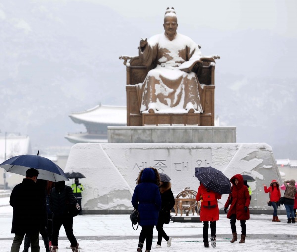 많은 눈이 내린 20일 오전 서울 중구 광화문광장에서 시민들이 눈을 맞으며 출근하고 있다. 뉴시스