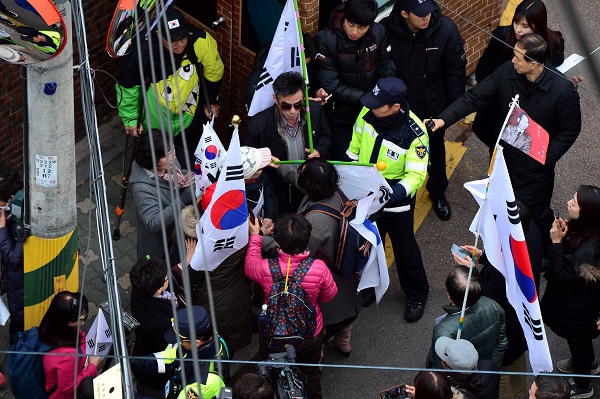 박근헤 전 대통령 서울 삼성동 사저 앞에 모인 박사모 한 남성이 한 여성에게 태극기를 겨누고 있다. 뉴시스
