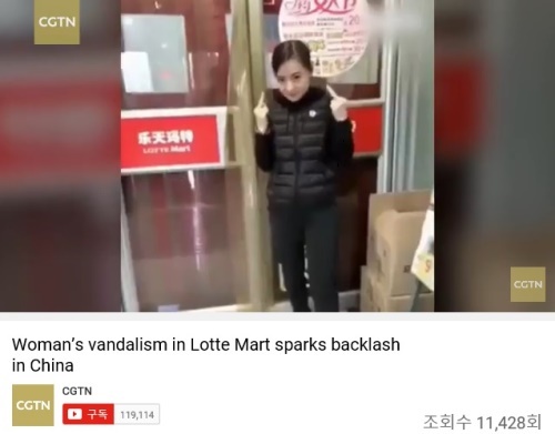 한 여성이 중국 내 롯데마트 팻말 옆에서 손가락으로 욕을 의미하는 포즈를 취하고 있다. 유투브 캡쳐