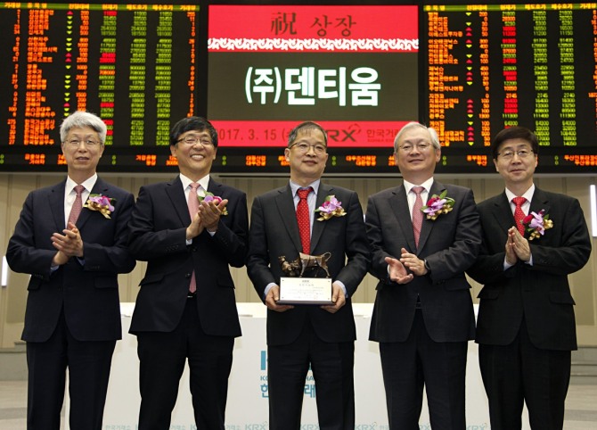 한국거래소 유가증권시장본부는 15일 오전8시40분부터 서울사옥 홍보관에서 치과용 임플란트 및 관련 기기 제조업체인 (주)덴티움의 유가증권시장 신규상장기념식을 개최했다. 상장기념패 전달 후 기념촬영 왼쪽부터 이호철 한국IR협의회 회장, 이은태 한국거래소 유가증권시장본부장, 강희택 (주)덴티움 대표이사, 정영채 NH투자증권 부사장, 김정운 한국상장회사협의회 부회장./사진=한국거래소
