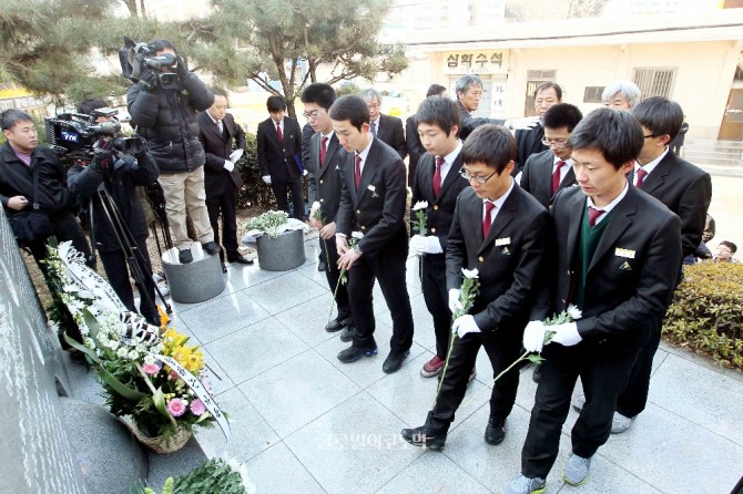 2001년 1월26일 일본 유학 중 지하철 선로에 떨어진 일본인 남성을 구하려다 숨진 고 이수현씨의 기일을 맞아 열린 추모행사에 이씨의 모교 후배들이 학교 정문에 있는 이수현비에 헌화하고 있다. /사진=뉴시스