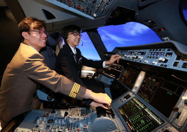 서울 강서구 아시아나타운 운항훈련동에서 27일 진행된 'A350 시뮬레이터 체험 프로그램'에서 신서중학교 이택현 군이 아시아나항공 황남식 기장에게 시뮬레이터 조작법 교육을 받고 있다. 