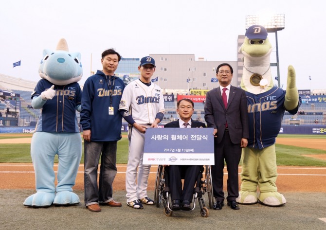 BNK경남은행 구삼조 부행장(오른쪽 두번째)과 NC다이노스 김명식 관리본부장 그리고 김준완 선수가 (사)한국척수장애인협회 경상남도협회 우길중 회장(오른쪽 세번째)에게 '사랑의 휠체어 기탁 증서'를 전달한 뒤 기념촬영하고 있다. BNK경남은행=제공