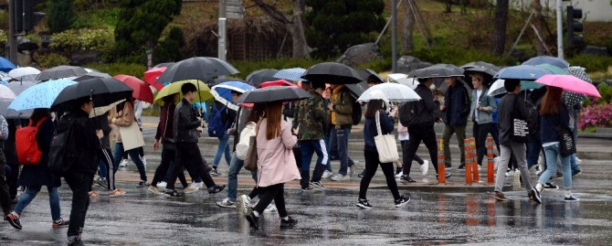 전국 곳곳에 비가 내린 지난 17일 오후 서울 서대문구 연세대학교 앞 횡단보도에서 학생과 시민들이 발걸음을 옮기고 있다./뉴시스