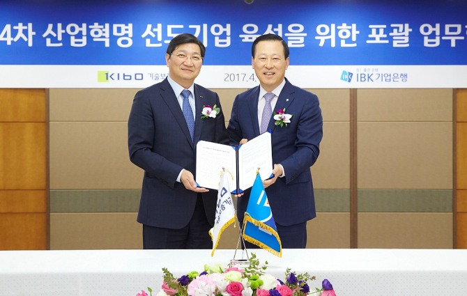 김도진 기업은행장(오른쪽)과 김규옥 기술보증기금 이사장이 협약식을 마치고 기념촬영을 하고 있다.
