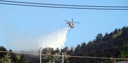 지난 6일 오후 발생한 강원 강릉시 성산면 산불이 밤에도 꺼지지 않은 가운데 7일 오전 강원 강릉시 성산면 야산에서 소방헬기가 물을 뿌리고 있다./뉴시스