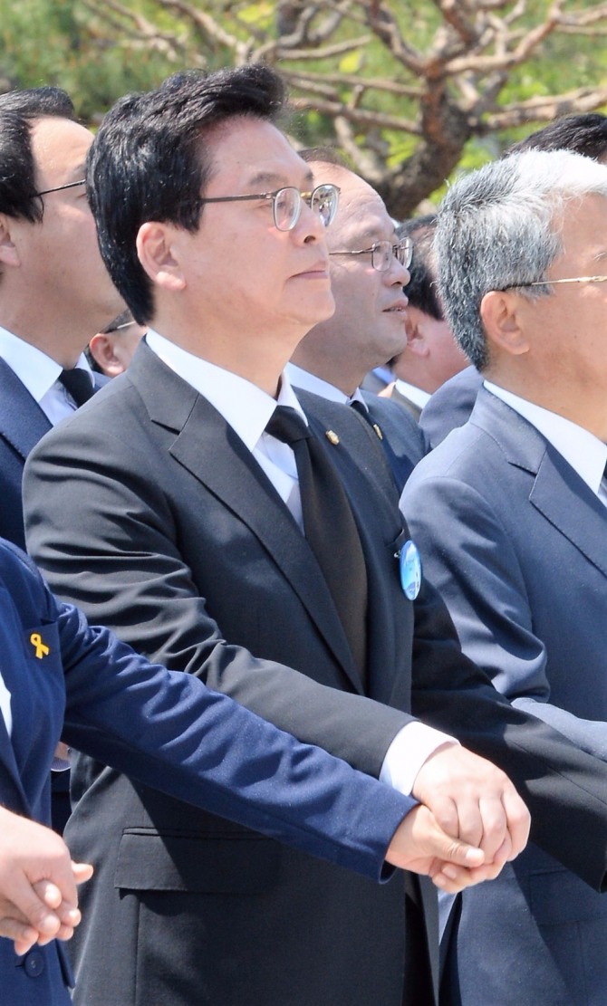 18일 오전 제37주년 5·18 민주화운동 기념식이 열린 광주광역시 북구 운정동 국립 5·18민주묘지에서 참석자들이 임을 위한 행진곡 제창 중 정우택 자유한국당 대표 권한대행 원내대표가 입을 다문 채 손을 흔들고 있다. 사진=뉴시스 