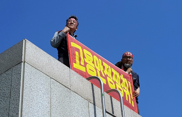 금속노조 현대중공업지부 김진석 수석부지부장과 김병조 정책기획실장이 울산시의회 건물 옥상에 올라 점거 농성을 벌이고 있다.뉴시스=사진
