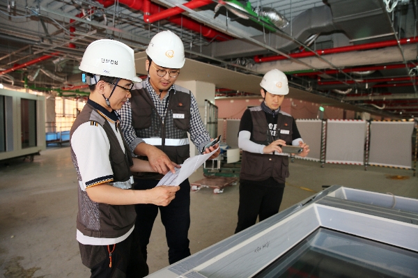 한화건설 직원들이 서울 장교동 한화빌딩 리모델링 공사현장에서 모바일 어플리케이션을 활용해 안전관리를 진행하고 있다.