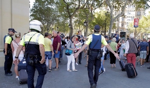 17일(현지시간) 스페인 바르셀로나 유명 관광지인 라스 람블라스 구역에서 차량 인도 돌진 사건이 발생한 가운데 경찰이 시민들에게 현장에서 벗어날 것을 요구하고 있다. 이날 바르셀로나에서 흰색 밴 차량이 인도로 돌진해 다수의 부상자가 발생했다. /사진=AP 뉴시스