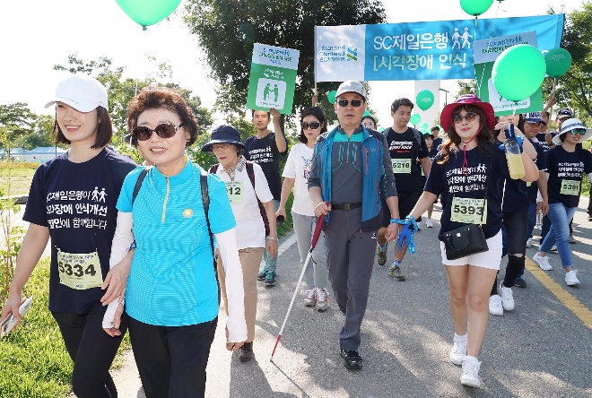 SC제일은행 임직원들이 2일 서울 여의도 한강공원에서 열린 '제 3회 시각장애인과 함께 뛰는 어울림 마라톤 대회'에서 시각장애인들의 가이드 러너 역할을 수행하고 있다.