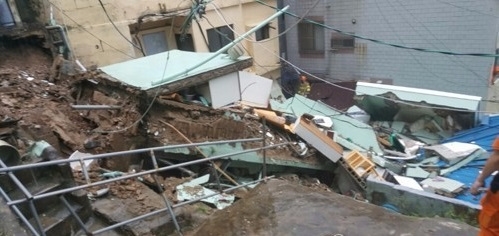 부산지역에 폭우가 내린 11일 오전 부산 중구 동광동의 한 주택이 무너져 소방대원들이 구조작업을 펼치고 있다./사진=연합뉴스
