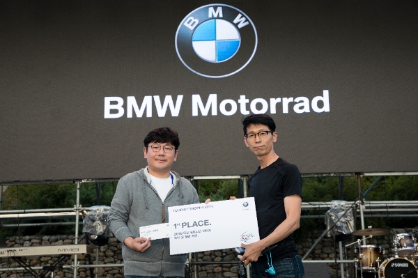 누적 주행거리 1등을 차지한 박종렵씨가 이상훈 BMW 모토라드 총괄이사로부터 숙박 및 항공권을 받고 있다 / 사진=BMW 모토라드 제공